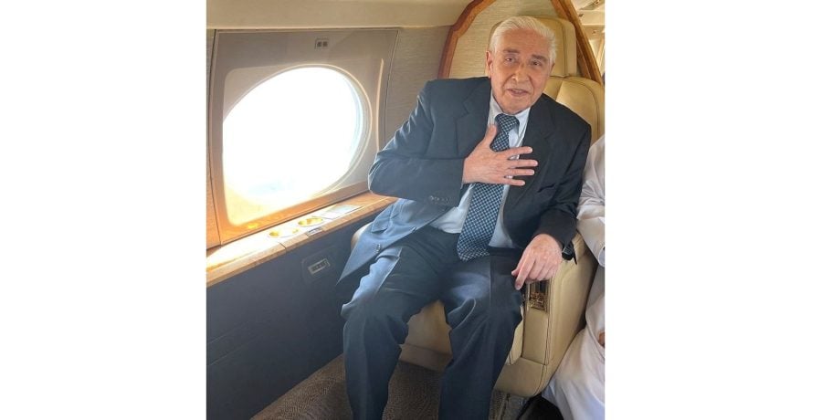 Baquer Namazi gestures prior to takeoff to Muscat, Oman, on board airplane in Tehran, Iran October 5, 2022. Courtesy of Namazi family/via REUTERS