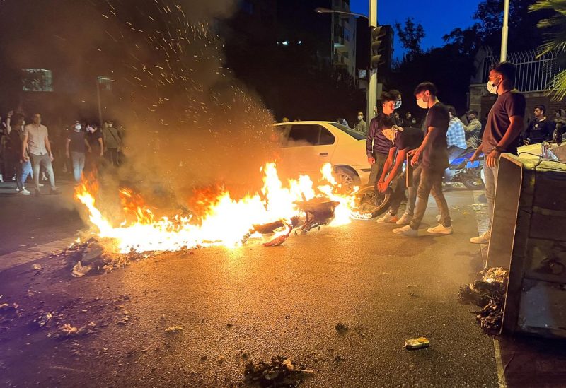 A police motorcycle burns during a protest over the death of Mahsa Amini, a woman who died after being arrested by the Islamic republic's "morality police", in Tehran, Iran September 19, 2022. WANA (West Asia News Agency) via REUTERS