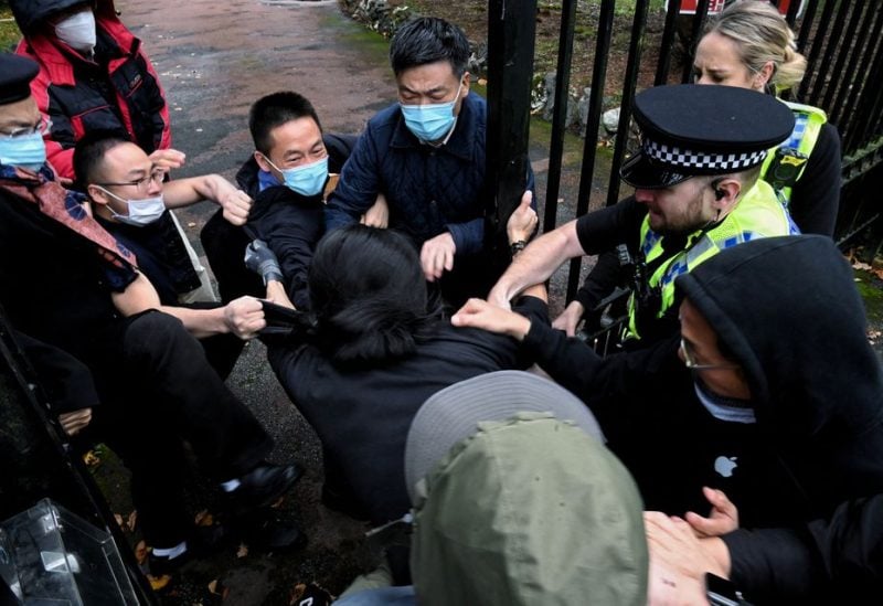 A man is pulled at the gate of the Chinese consulate after a demonstration against China's President Xi Jinping, in Manchester, Britain October 16, 2022. Matthew Leung/The Chaser News/Handout via REUTERS