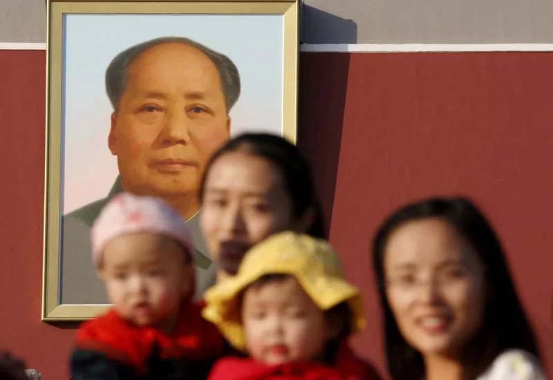 Two women and their babies pose for photographs in front of the giant portrait of late Chinese chairman Mao Zedong on the Tiananmen Gate in Beijing November 2, 2015. REUTERS