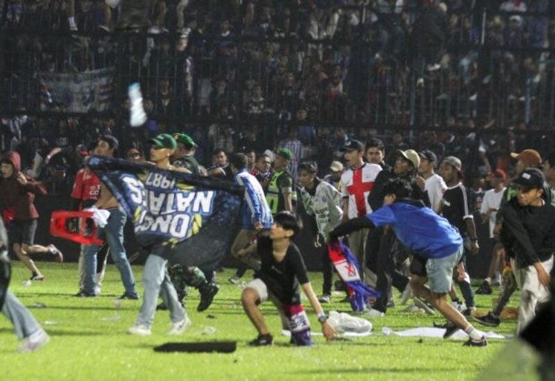 Arema FC supporters enter the field after the team they support lost to Persebaya after the league BRI Liga 1 football match in Malang
