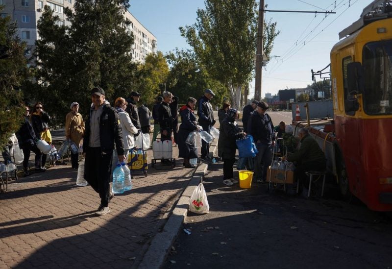 Local people queue to fill up bottles with fresh drinking water, as the main supply pipeline for drinking water for the city was damaged in Kherson region at the beginning of Russia's attack on Ukraine, in Mykolaiv, Ukraine October 16, 2022. REUTERS
