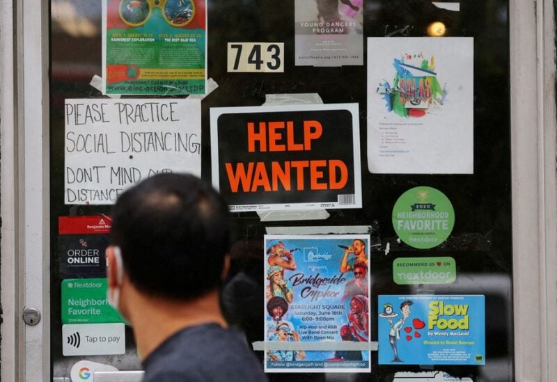 A pedestrian passes a "Help Wanted" sign in the door of a hardware store in Cambridge, Massachusetts, U.S., July 8, 2022. REUTERS