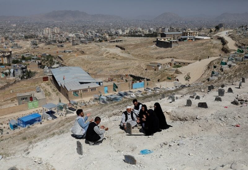 The family members of Um al-Banin, who was killed in a suicide attack in a tutoring center in Dasht-e-Barchi district in the west of Kabul, pray at her grave in Kabul, Afghanistan, October 2, 2022. REUTERS/Ali Khara