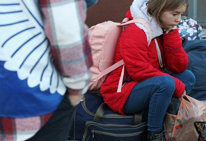 FILE PHOTO: A girl sits on a bag as civilians evacuated from the Russian-controlled Kherson region of Ukraine arrive at a railway station in the town of Dzhankoi, Crimea October 24, 2022. REUTERS/Alexey Pavlishak/File Photo