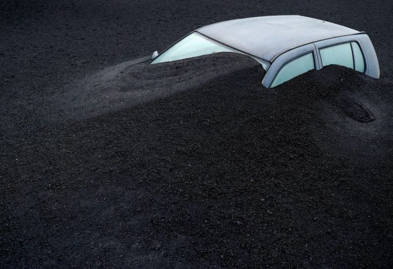 A vehicle is seen buried in the ash from the Cumbre Vieja volcano in Las Manchas neighbourhood, on the Canary Island of La Palma, Spain, January 20, 2022. Picture taken January 20, 2022. REUTERS/Borja Suarez