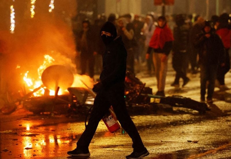 Clashes in Brussels after the World Cup football match between Belgium and Morocco - Brussels, Belgium - November 27, 2022 A man with his face covered and a fire extinguisher is seen during clashes after the World Cup match between Belgium and Morocco REUTERS/Yves Herman