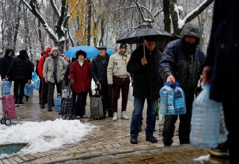 Local residents stand in line to fill up bottles with fresh drinking water after critical civil infrastructure was hit by Russian missile attacks in Kyiv, Ukraine November 24, 2022. REUTERS/Valentyn Ogirenko