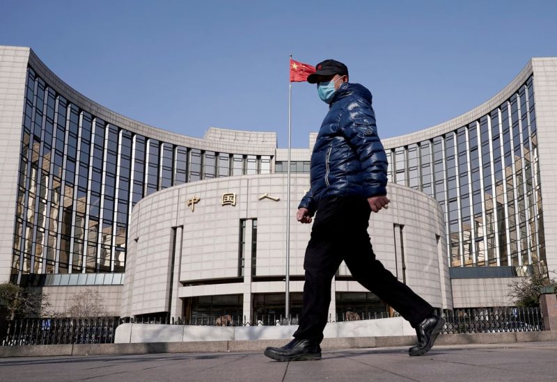 A man wearing a mask walks past the headquarters of the People's Bank of China, the central bank, in Beijing, China, as the country is hit by an outbreak of the new coronavirus, February 3, 2020. REUTERS/Jason Lee