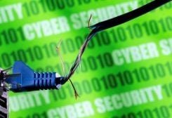 Broken Ethernet cable is seen in front of binary code and words "cyber security" in this illustration taken March 8, 2022. REUTERS/Dado Ruvic/Illustration