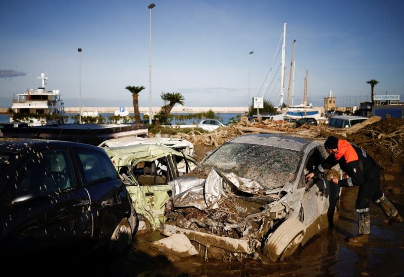 A member of the Coast Guard looks for documents inside a destroyed car, following a landslide on the Italian island of Ischia, Italy November 28, 2022. REUTERS/Guglielmo Mangiapane