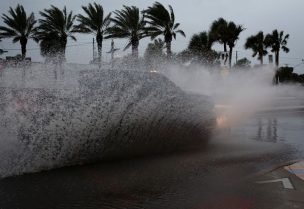 A car drives by a flooded street ahead of the expected arrival of Hurricane Nicole, in Daytona Beach, Florida, U.S., November 9, 2022. REUTERS/Marco Bello