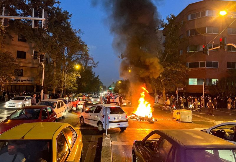 A police motorcycle burns during a protest over the death of Mahsa Amini, a woman who died after being arrested by the Islamic republic's "morality police", in Tehran, Iran September 19, 2022. WANA (West Asia News Agency) via REUTERS