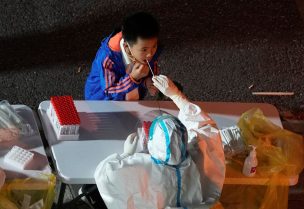 A boy gets tested for the coronavirus disease (COVID-19) at a nucleic acid testing site, following the coronavirus disease (COVID-19) outbreak in Shanghai, China, November 9, 2022. REUTERS/Aly Song