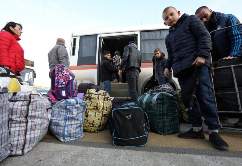 Civilians evacuated from the Russian-controlled Kherson region of Ukraine get off a bus as they arrive at a local railway station, after Russian-installed officials extended an evacuation order to the area along the eastern bank of the Dnipro River, in the town of Dzhankoi, Crimea November 2, 2022. REUTERS/Alexey Pavlishak