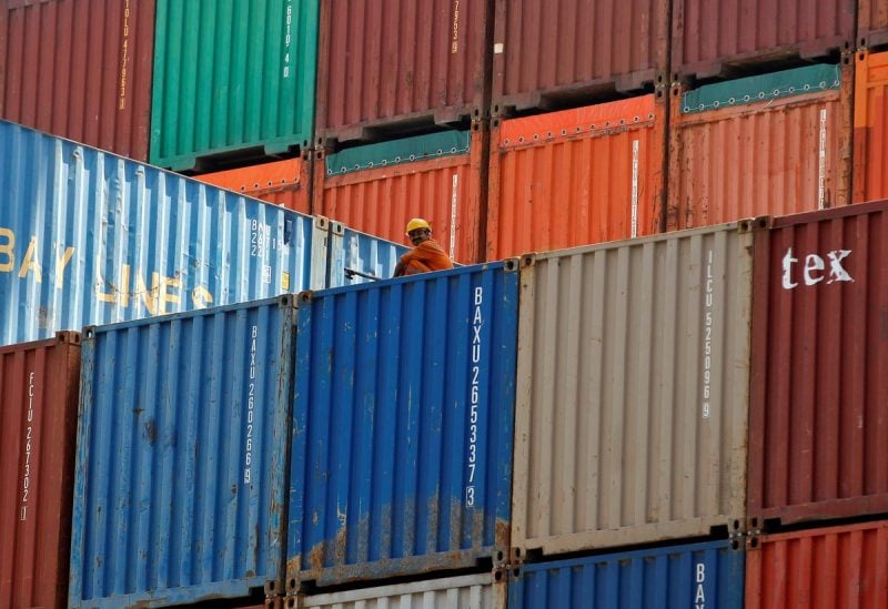 FILE PHOTO - A worker sits on a ship carrying containers at Mundra Port in the western Indian state of Gujarat April 1, 2014. REUTERS/Amit Dave
