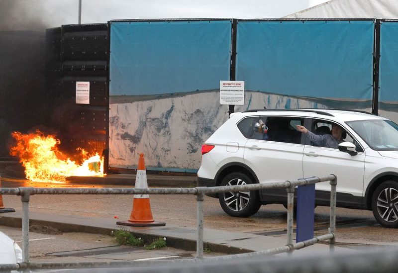 A man throws an object out of a car window next to the Border Force centre after a firebomb attack in Dover, Britain, October 30, 2022. REUTERS