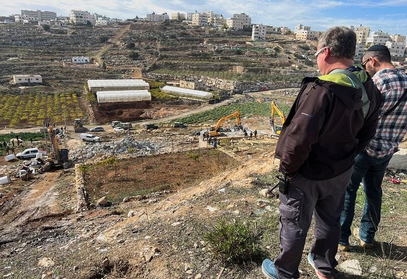 Israeli workers watch as Israeli machinery demolishes a Palestinian house, in Hebron, in the Israeli-occupied West Bank, November 28, 2022. REUTERS/Yosri Aljamal REFILE- CORRECTING IDs