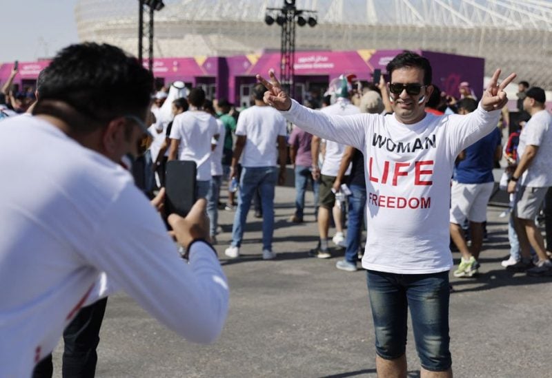 An Iran fan wearing a t-shirt with the message 'Woman life freedom' outside the stadium before the match - REUTERS