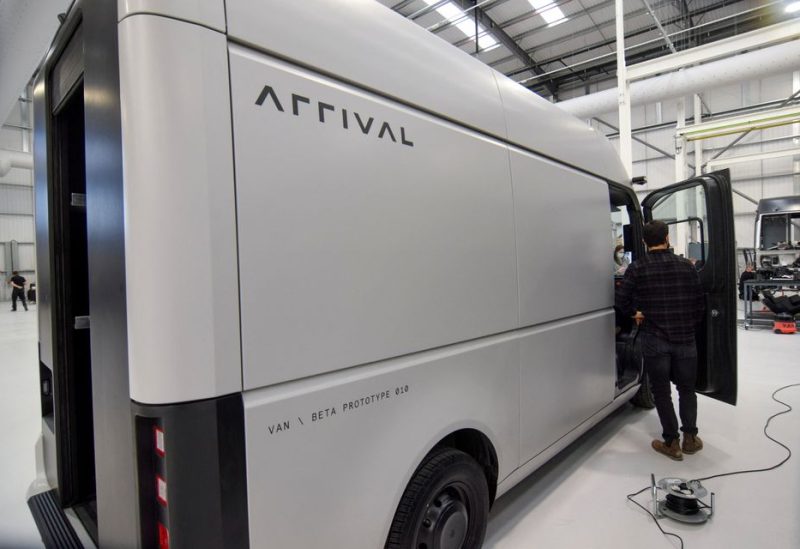 A man stands next to a fully electric test van, due to go into production in 2022, built by electric van and bus maker Arrival Ltd, that has seen a spike in interest due to soaring e-commerce amid the coronavirus disease (COVID-19) pandemic and looming fossil-fuel vehicle bans, in Banbury, Britain, February 23, 2021. REUTERS