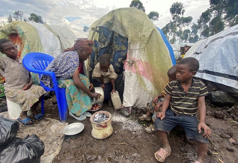 Paskazia Kimanuka 58, sits with her children outside their makeshift shelter at the Kanyaruchinya camp for the internally displaced people near Goma in the North Kivu province of the Democratic Republic of Congo November 22, 2022. REUTERS/Djaffar Sabiti