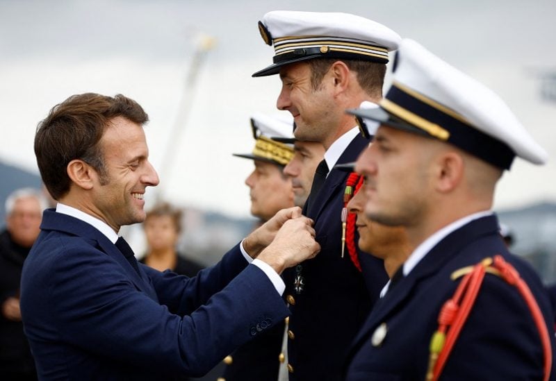 French President Emmanuel Macron decorates soldiers from the deck of the amphibious helicopter carrier Dixmude docked in the French Navy base of Toulon, France, November 9, 2022. REUTERS/Eric Gaillard/Pool ?