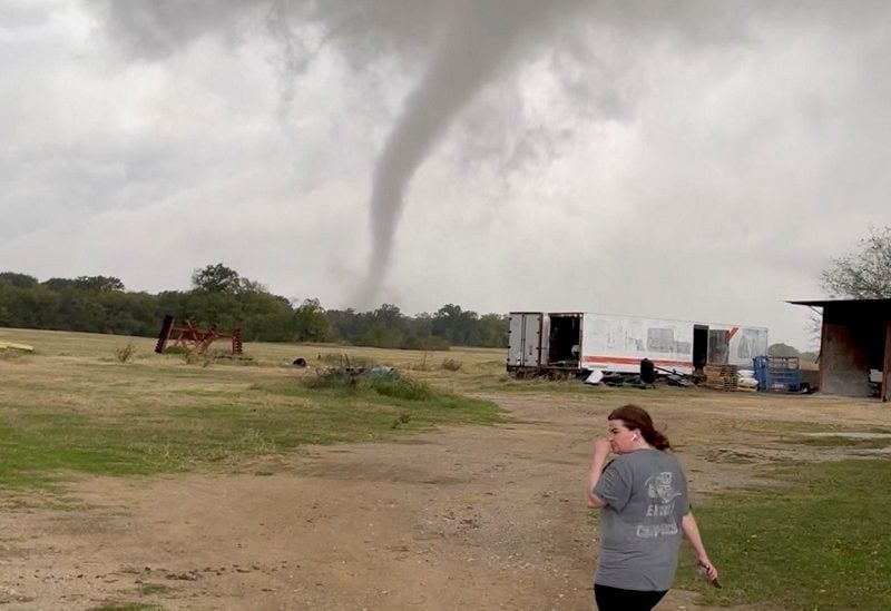 A woman walks in a farm as the funnel cloud of a tornado is seen in the background, in Greenview, Texas, U.S, November 4, 2022, in this screen grab taken from social media video. TWITTER @RCF_2008/via REUTERS THIS IMAGE HAS BEEN SUPPLIED BY A THIRD PARTY. MANDATORY CREDIT. NO RESALES. NO ARCHIVES.