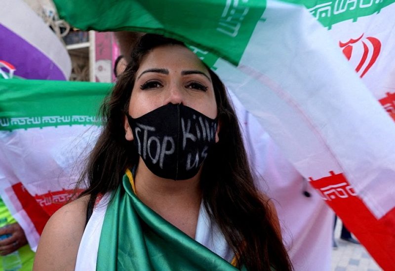 FILE PHOTO: Soccer Football - FIFA World Cup Qatar 2022 - Group B - Wales v Iran - Ahmad Bin Ali Stadium, Al Rayyan, Qatar - November 25, 2022. A woman wearing a mask with a message reading 'stop killing us' after the match. REUTERS/Charlotte Bruneau/File Photo