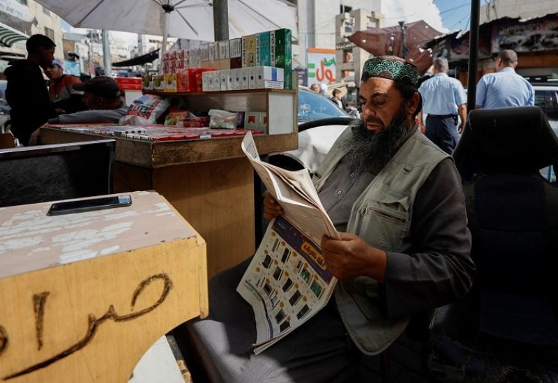A Palestinian vendor reads news about Israeli elections in a newspaper, in Hebron in the Israeli-occupied West Bank November 2, 2022. REUTERS/Mussa Qawasma