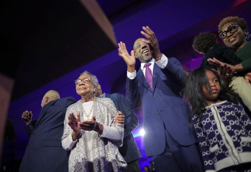 U.S. Senator Raphael Warnock (D-GA) is joined on stage by his mother Verlene Warnock and his daughter Chloe and son Caleb during an election night party after a projected win in the U.S. midterm runoff election between Warnock and his Republican challenger Herschel Walker in Atlanta, Georgia, U.S., December 6, 2022. REUTERS/Carlos Barria