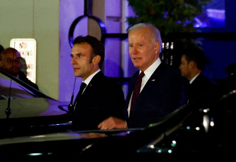 U.S. President Joe Biden and French President Emmanuel Macron walk next to vehicles as they meet for dinner at Fiola Mare restaurant in the Georgetown neighborhood of Washington, U.S., November 30, 2022. REUTERS/Evelyn Hockstein