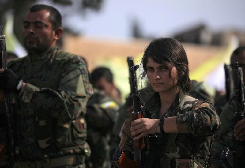 A fighter of Syrian Democratic Forces (SDF) holds her weapon as they announce the destruction of Islamic State's control of land in eastern Syria, at al-Omar oil field in Deir Al Zor, Syria March 23, 2019. REUTERS/Rodi Said/File Photo
