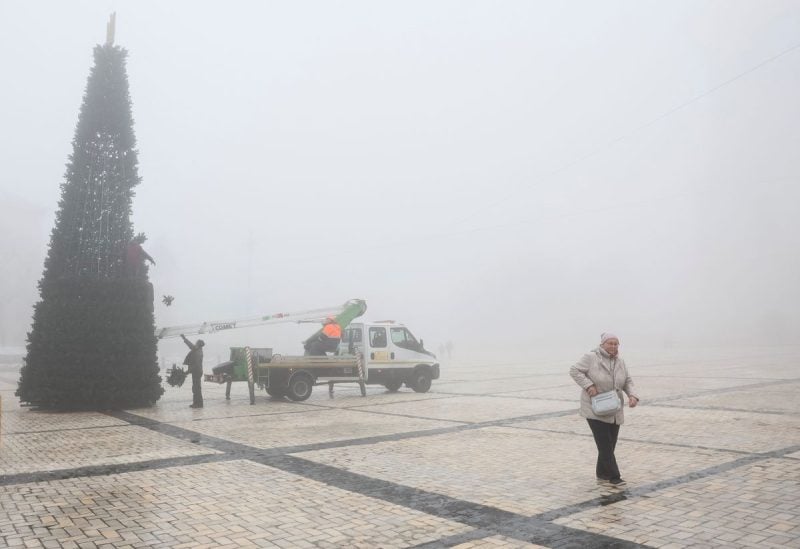 Municipal workers install a Christmas tree during a heavy fog at the Sofiyska square, amid Russia's invasion of Ukraine, in Kyiv, Ukraine December 17, 2022. REUTERS/Gleb Garanich