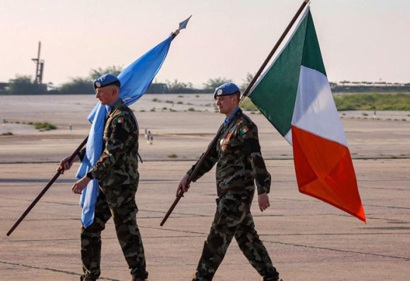 Irish peacekeepers of the United Nations Interim Force in Lebanon (UNIFIL) walk with the UN and Irish flags during the repatriation ceremony for Irish soldier Seán Rooney who was killed on a UN patrol, at Beirut international airport on December 18, 2022. (AFP)