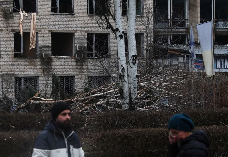 People stand outside a university damaged from a recent missile attack in Kramatorsk Ukraine, December 13, 2022. REUTERS/Shannon Stapleton
