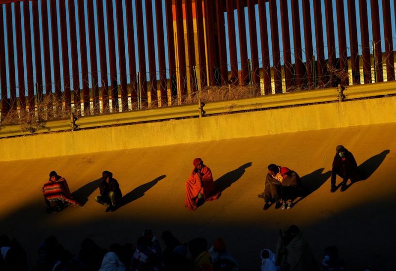 Migrants gather near the border wall after crossing the Rio Bravo river to turn themselves in to U.S. Border Patrol agents to request asylum in the U.S. city of El Paso, Texas, as seen from Ciudad Juarez, Mexico December 14, 2022. REUTERS/Jose Luis Gonzalez