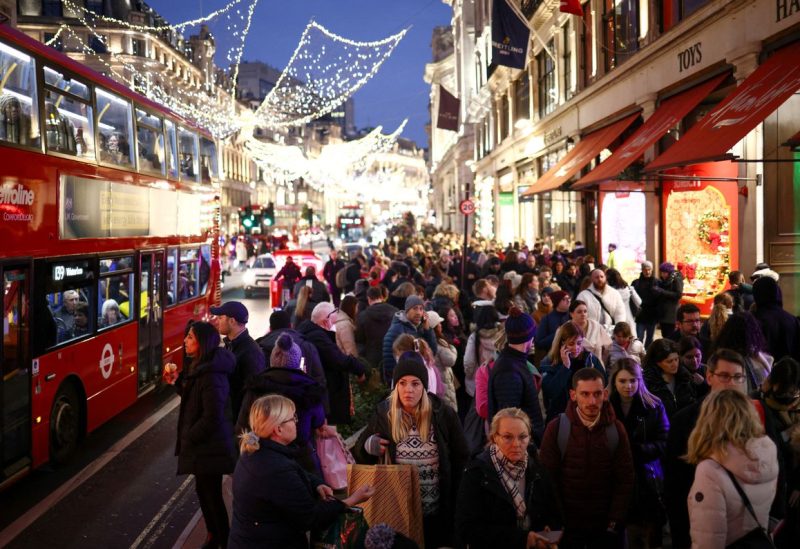 People carry shopping bags as they walk past Christmas themed shop displays on Regent Street in London, December 4, 2022. REUTERS/Henry Nicholls
