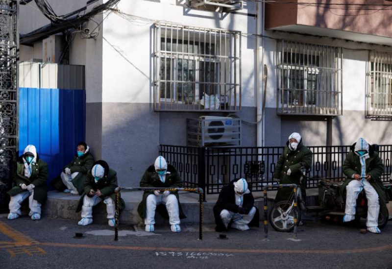 Pandemic control workers in protective suits sit in a neighbourhood that used to be under lockdown, as coronavirus disease (COVID-19) outbreaks continue, in Beijing, China December 10, 2022. REUTERS/Thomas Peter