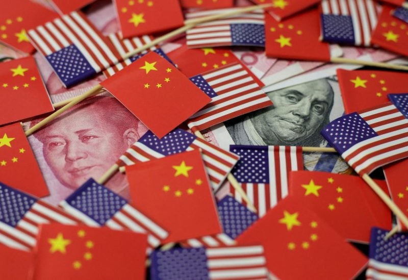 A U.S. dollar banknote featuring American founding father Benjamin Franklin and a China's yuan banknote featuring late Chinese chairman Mao Zedong are seen among U.S. and Chinese flags in this illustration picture taken May 20, 2019. REUTERS/Jason Lee/Illustration/File Photo