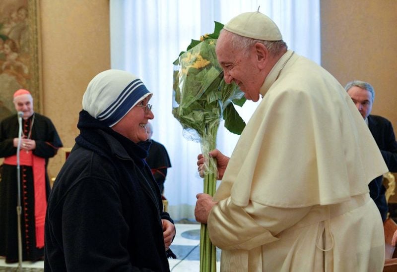 Pope Francis reacts as he receives flowers from a nun during his 86th birthday celebration as he meets with the delegation of Mother Teresa Award at the Vatican, December 17, 2022. Vatican Media/­Handout via REUTERS