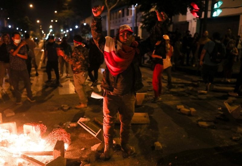 A demonstrator gestures next to a bonfire during a protest demanding the dissolution of Congress and to hold democratic elections rather than recognize Dina Boluarte as Peru's President, after the ouster of Peruvian leader Pedro Castillo, in Lima, Peru December 11, 2022. REUTERS/Sebastian Castaneda