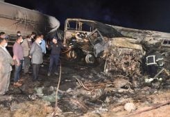 In this photo provided by Assiut Governorate media office, the authorities work on the collision site where a bus overturned, while trying to pass a truck on a highway in southern Egypt on Wednesday, April 14, 2021, near the city of Assiut, Egypt.