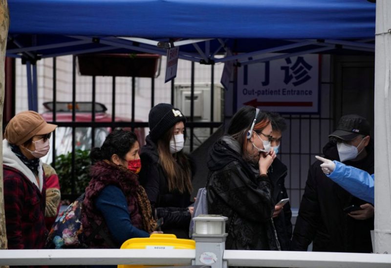 A woman takes a rapid antigen test for COVID-19 at an entrance of a hospital, as coronavirus disease (COVID-19) outbreaks continue in Shanghai, China, December 12, 2022. REUTERS