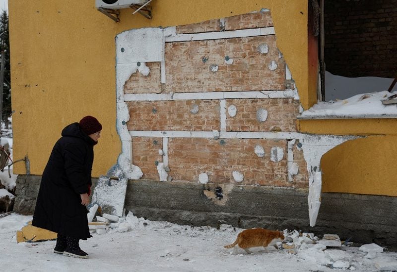 A local woman walks next to a wall of a residential building, heavily damaged during Russian invasion, from which a group of people tried to steal the work of street artist Banksy, in the town of Hostomel, Kyiv region, Ukraine December 3, 2022. REUTERS/Valentyn Ogirenko