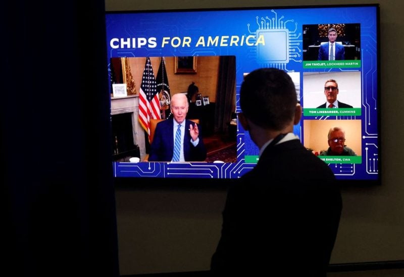 A White House press aide looks on as U.S. President Joe Biden, isolating following his COVID-19 diagnosis, appears virtually in a meeting with business and labor leaders about the Chips Act — relating to U.S. domestic chip and semiconductor manufacturing — in an auditorium on the White House campus in Washington, U.S., July 25, 2022 - REUTERS