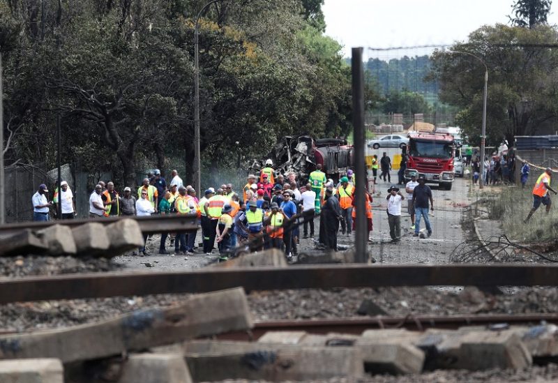 FILE PHOTO: People gather near a burnt out truck at the entrance of the damaged bridge where a gas tanker exploded in Boksburg near Johannesburg, South Africa, December 24, 2022. REUTERS/Sumaya Hisham/File Photo