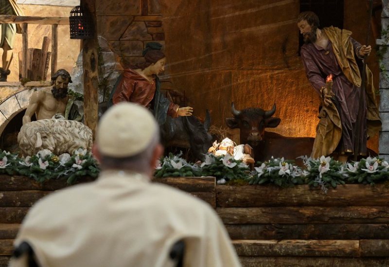 Pope Francis looks at a statue of baby Jesus while celebrating Christmas Eve mass in St. Peter's Basilica at the Vatican, December 24, 2022. Vatican Media/­Handout via REUTERS ATTENTION EDITORS - THIS IMAGE WAS PROVIDED BY A THIRD PARTY.