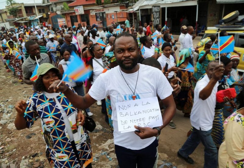 A protester holds a sign that says "no the balkanization of our country RDC" during a protest march that was called by Congo's Catholic and Protestant churches to protest against escalating violence in the East of the country, in Kinshasa, Democratic Republic of Congo, December 4, 2022 - REUTERS