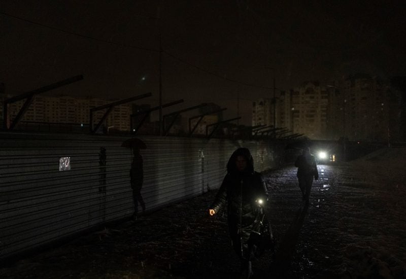 Women walk along a dark street after critical civil infrastructure was hit by Russian missile attacks, amid Russia's invasion of Ukraine, in Kyiv, Ukraine December 16, 2022. REUTERS/Valentyn Ogirenko