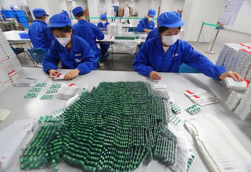 Workers pack medicine to treat symptoms of the coronavirus disease (COVID-19), at a factory of a medicine manufacturer, in Beijing, China December 11, 2022. China Daily vis REUTERS ATTENTION EDITORS - THIS IMAGE WAS PROVIDED BY A THIRD PARTY. CHINA OUT.
